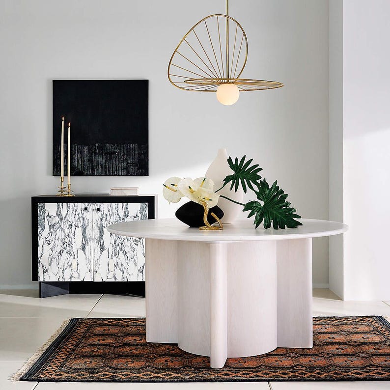 A Oushak Rugs fits with Modern interior with a white round table, black cabinet, and decorative elements. 